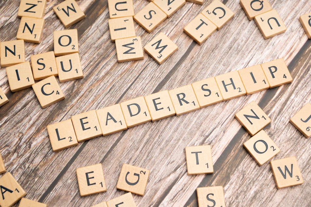 Wooden letter tiles spelling 'LEADERSHIP' on a wooden surface, symbolizing leadership qualities and skills.